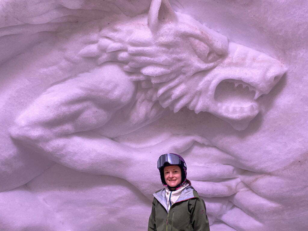wetransform's product manager Kate Lyndegaard, posing in front of a wolf-mural carved out of snow