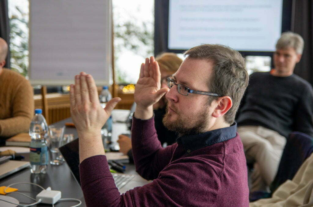 wetransform founder Simon raises his hands to applaud during a meeting