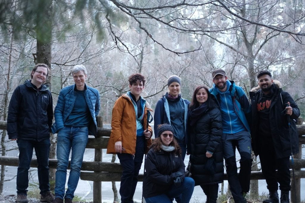eight members of the wetransform team pose in the forest.
