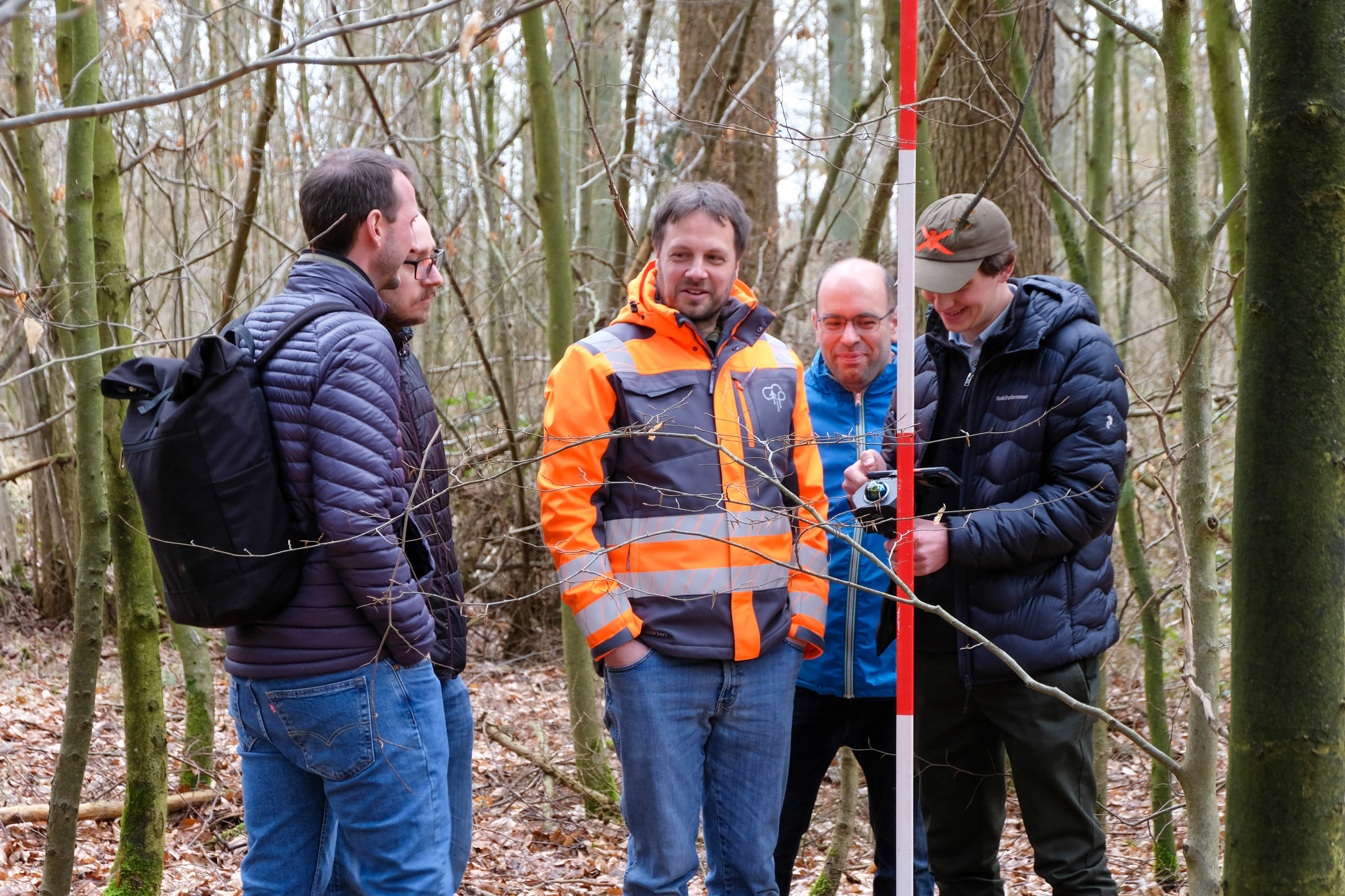 SmartForest 2026 participants chatting in a forest during a live tree-scanning demonstration at an outdoor conference session